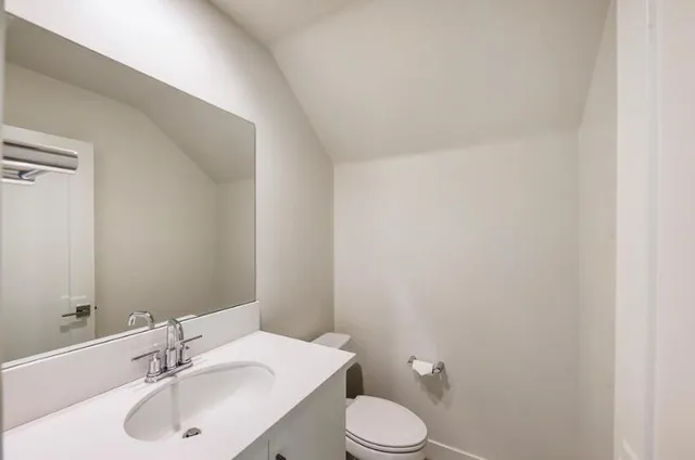 a bathroom with a sink toilet and a mirror