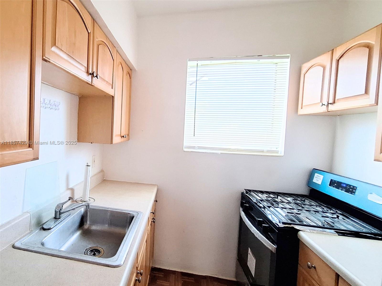 1770 Meridian Avenue, Unit 213 Miami Beach, FL 33139 - Photo 12 of 19 a kitchen with a sink stove and cabinets