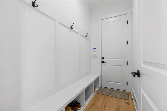 an empty room with wooden floor a ceiling fan and windows