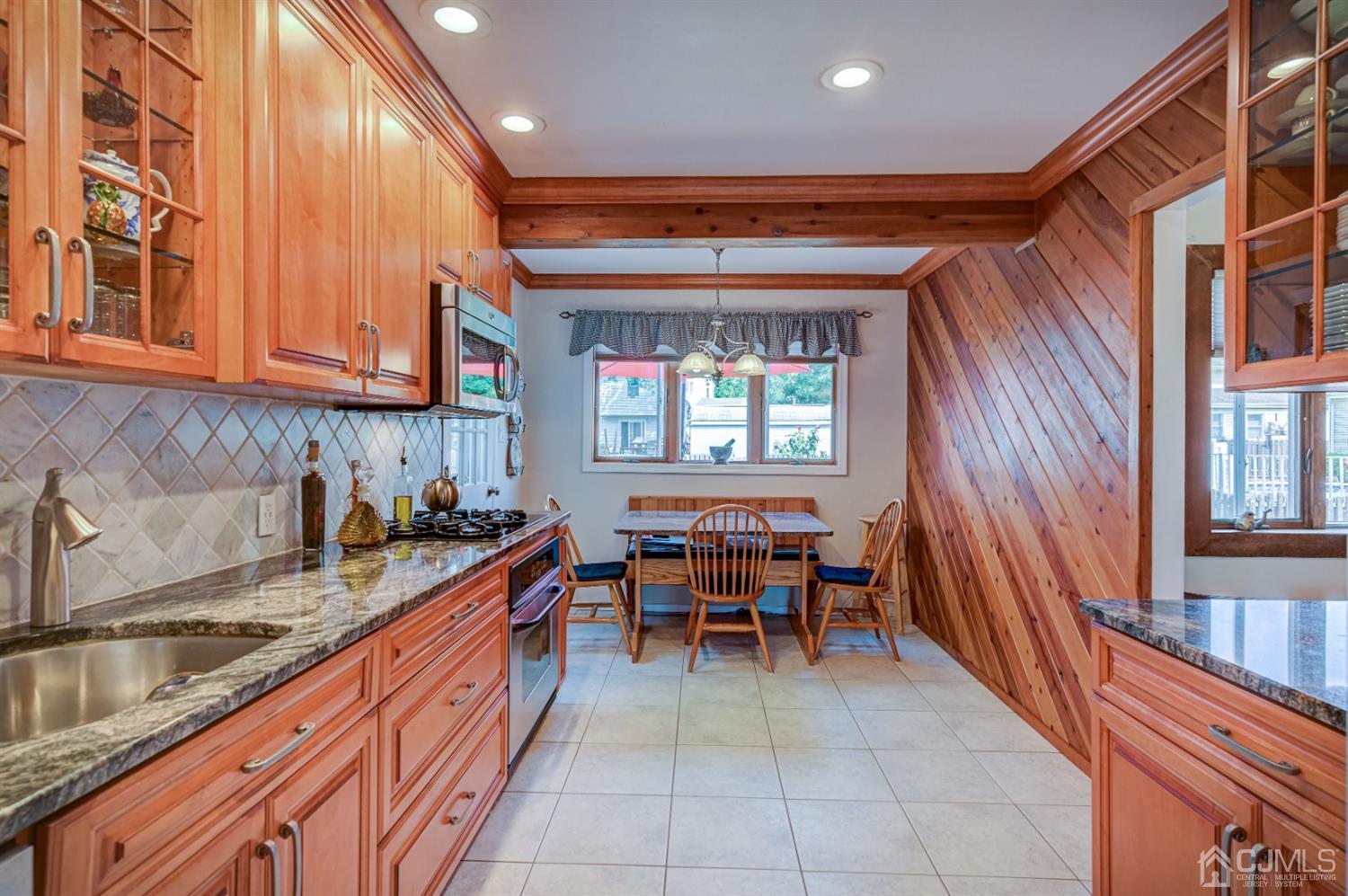 19 Chelsea Road Old Bridge, NJ 08857 - Photo 8 of 34 a kitchen with granite countertop lots of wooden cabinets a sink a stove and a window
