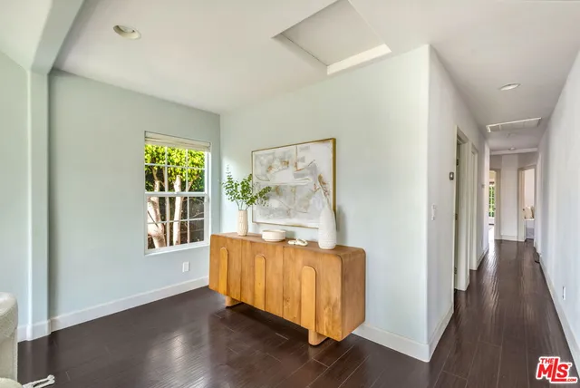 a view of a hallway with wooden floor and a window