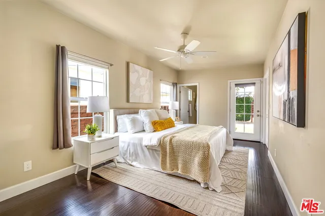 a bedroom with a large bed wooden floor and window