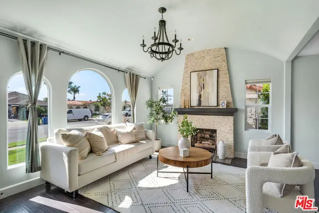 a living room with furniture a fireplace and a chandelier
