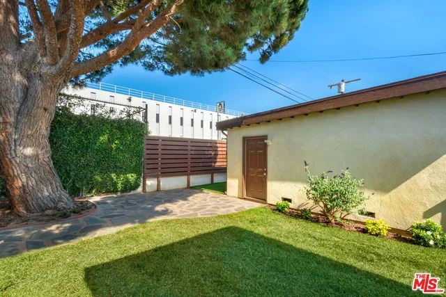 a view of a backyard with plants and a bench