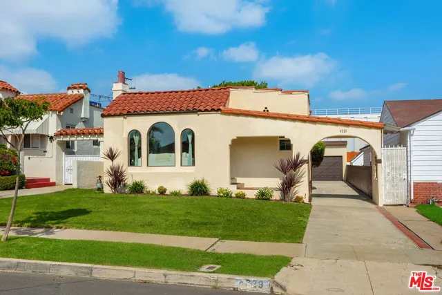 a front view of a house with a garden and plants