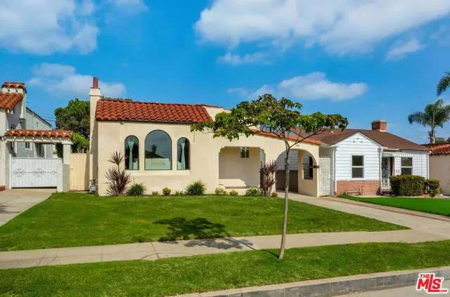 a view of a white house with a big yard and large trees