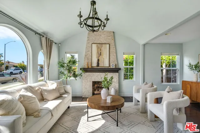a living room with furniture a chandelier and a window