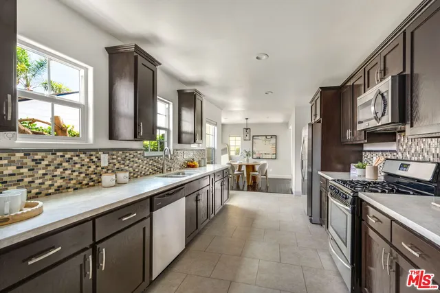 a kitchen with stainless steel appliances a sink stove and cabinets