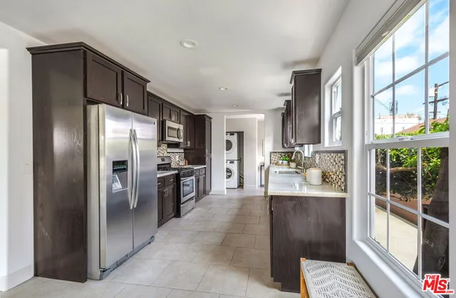 a kitchen with stainless steel appliances granite countertop a refrigerator and a stove top oven