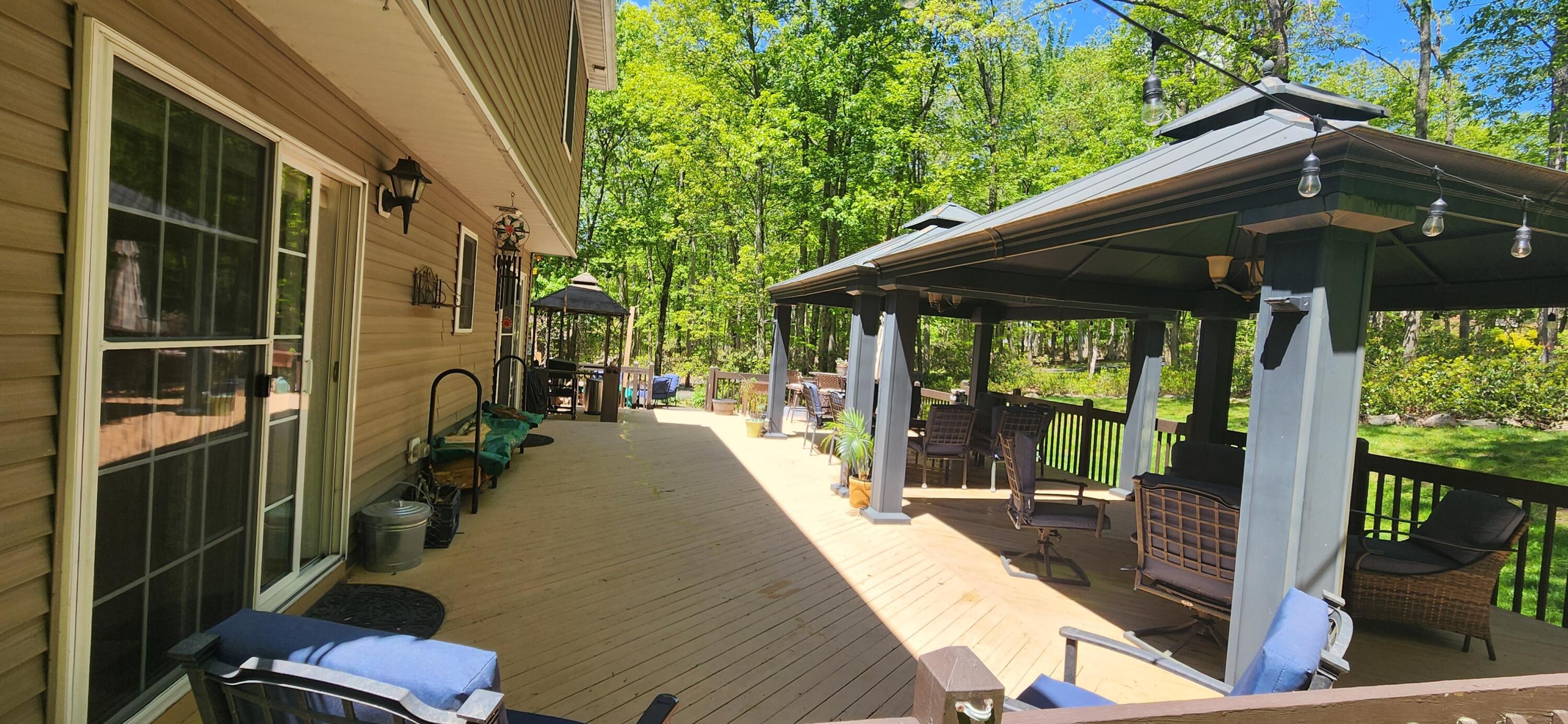 1729 Hemlock Drive Scotrun, PA 18355 - Photo 16 of 21 a view of a patio with table and chairs under an umbrella with a small yard