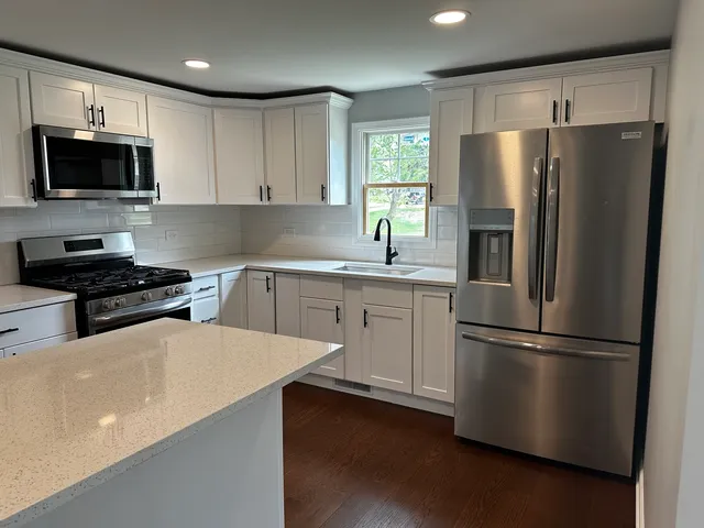 a kitchen with stainless steel appliances a refrigerator sink and microwave