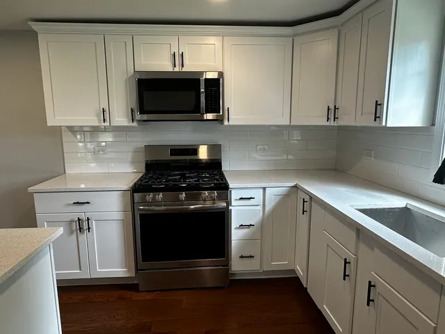 a kitchen with cabinets stainless steel appliances and a sink