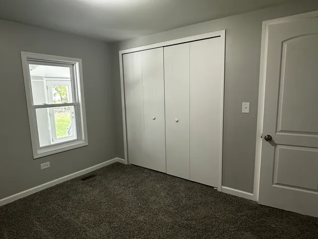 an empty room with windows and closet