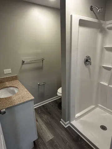 a bathroom with a granite countertop sink toilet and shower
