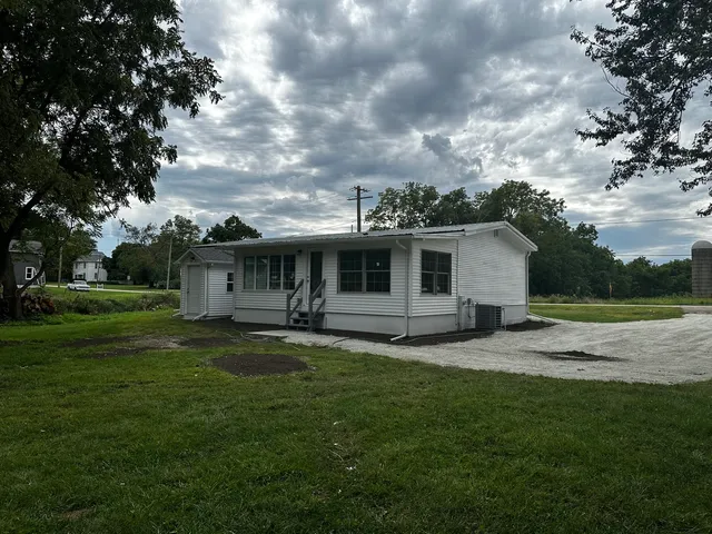 a backyard of a house with table and chairs