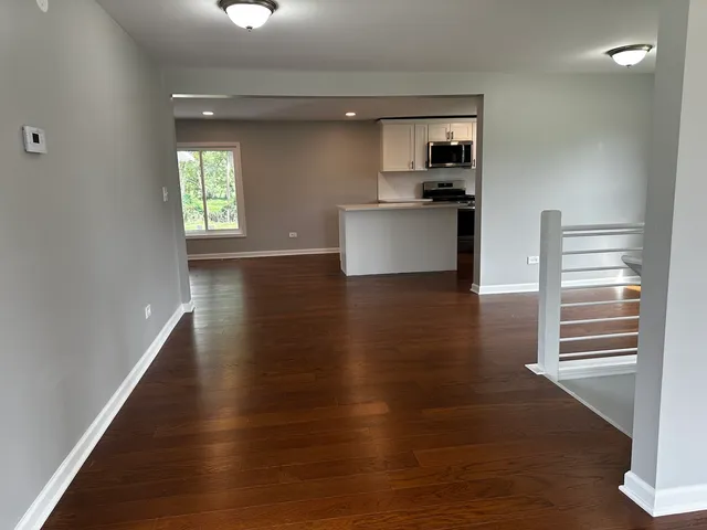 a view of a kitchen with wooden floor a sink and windows