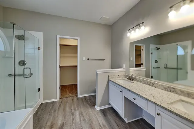 a bathroom with a granite countertop sink mirror and shower