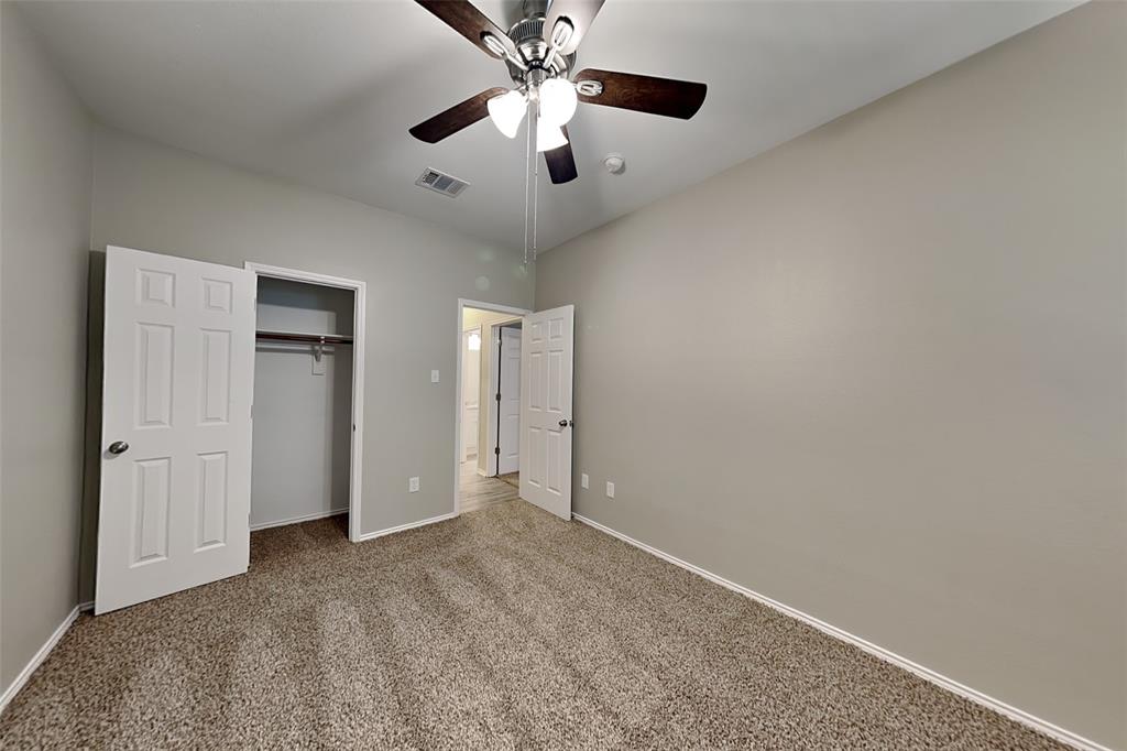 1056 Pullman Drive Saginaw, TX 76131 - Photo 16 of 27 an empty room with closet and a chandelier fan