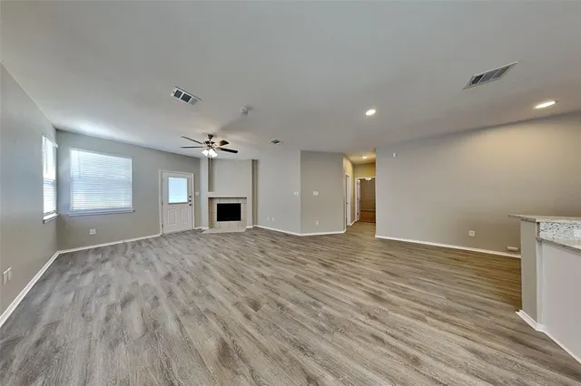 a view of empty room with a fireplace and wooden floor