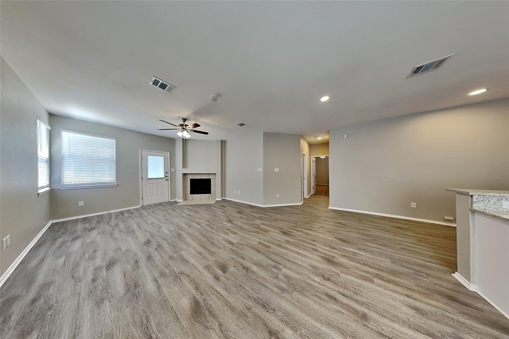 1056 Pullman Drive Saginaw, TX 76131 - Photo 7 of 27 a view of empty room with a fireplace and wooden floor