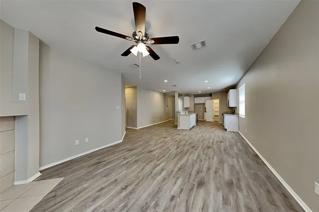 a view of empty room with wooden floor and window