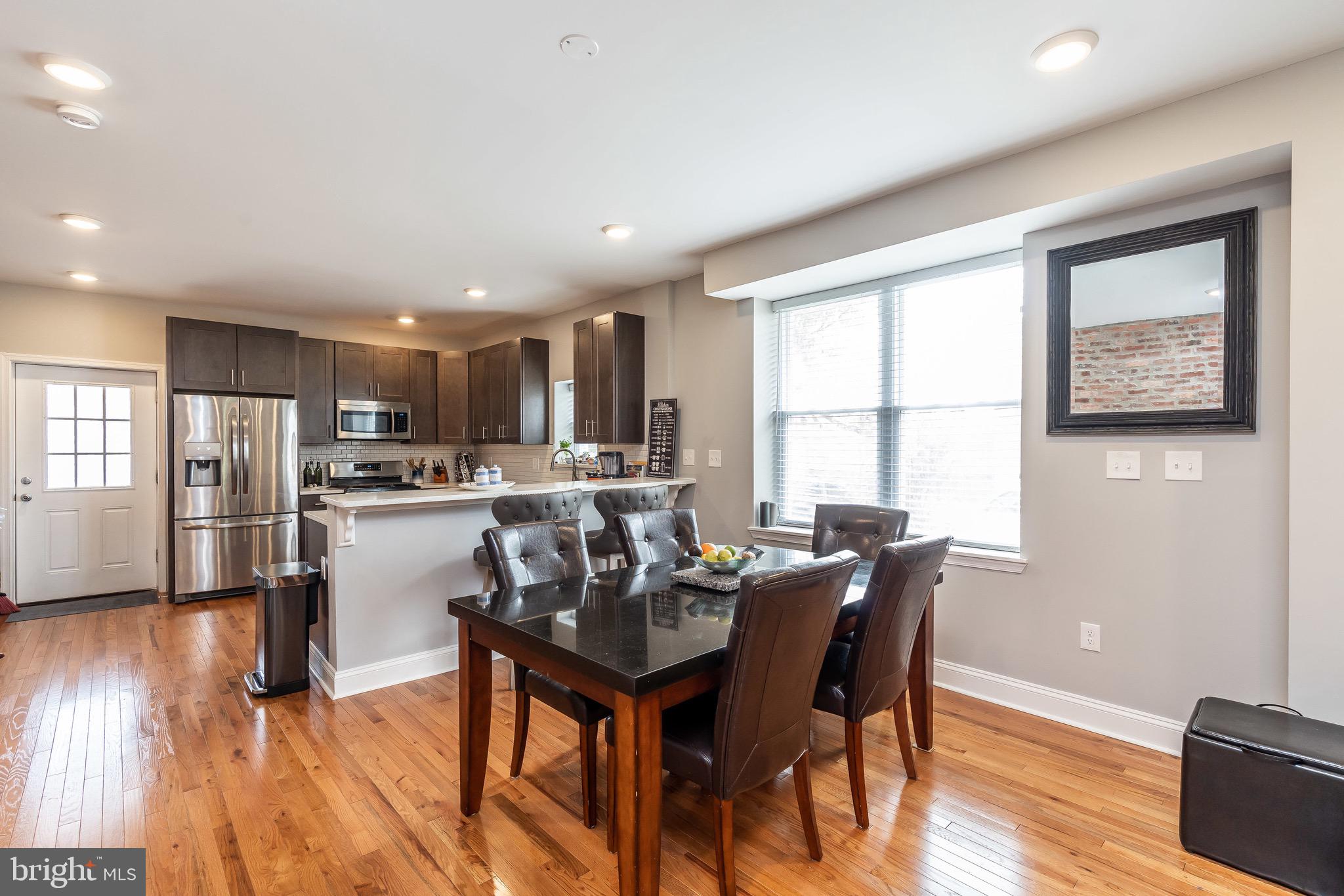 365 Bonsal Street Baltimore, MD 21224 - Photo 6 of 36 a living room with stainless steel appliances kitchen island granite countertop furniture and a wooden floor
