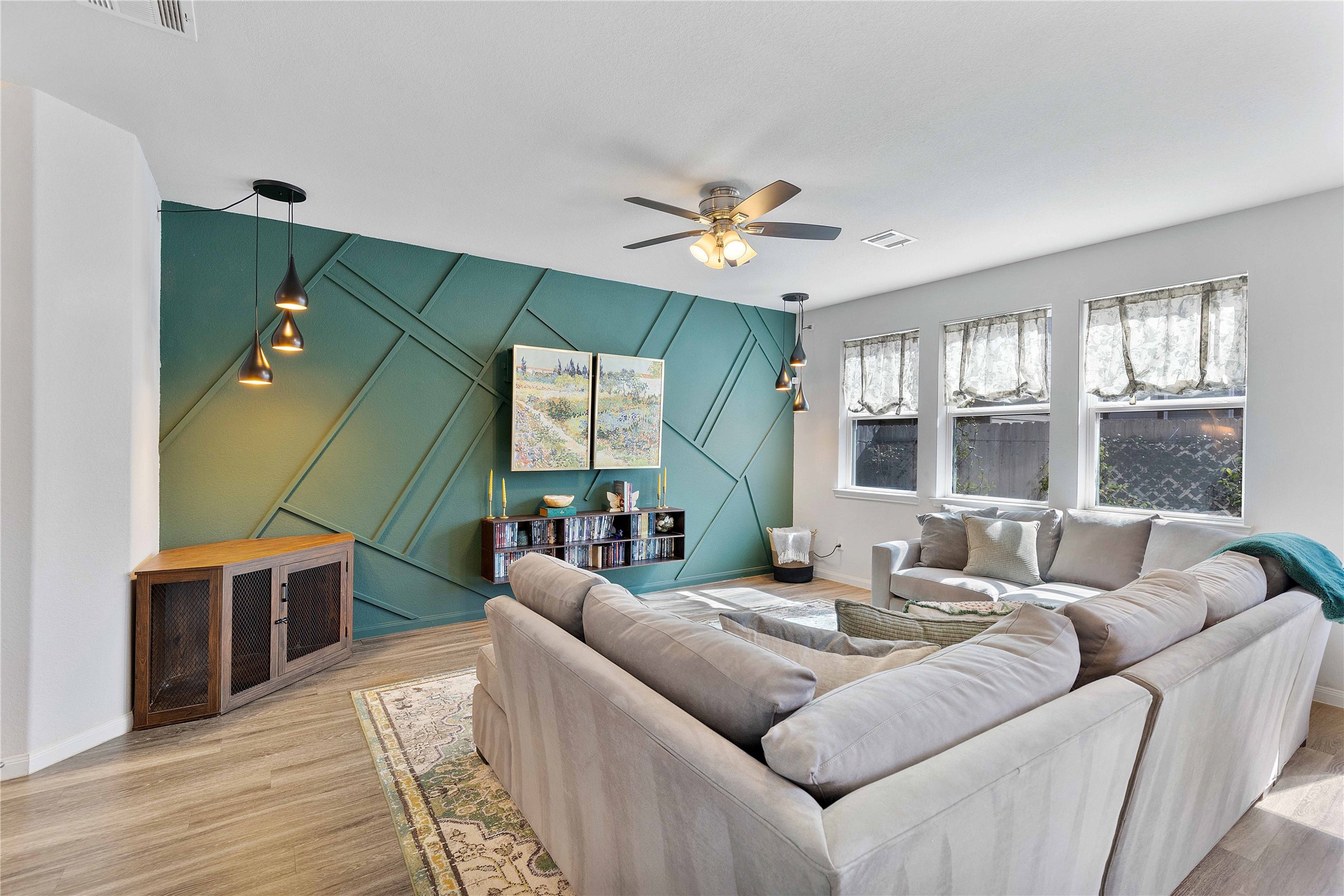 18623 Jerrara Stream Lane Katy, TX 77449 - Photo 3 of 46 Filled with natural light, this living room has more than enough room for your large sectional furniture. Artwork has been transformed to hide the TV for a more upscale look.