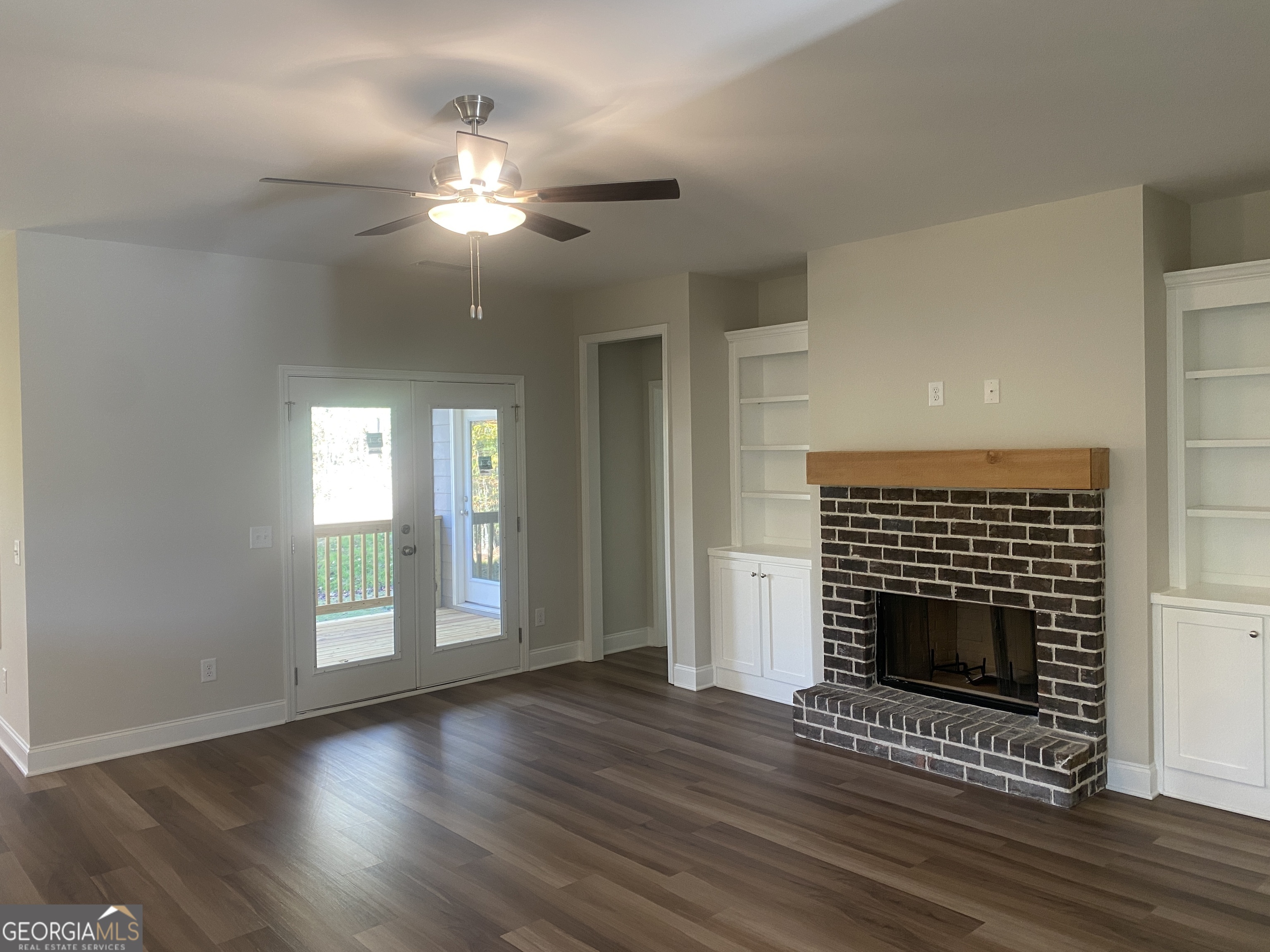 296 Delightful Way, Unit 22 Winder, GA 30680 - Photo 3 of 13 a view of an empty room with wooden floor fireplace and a window