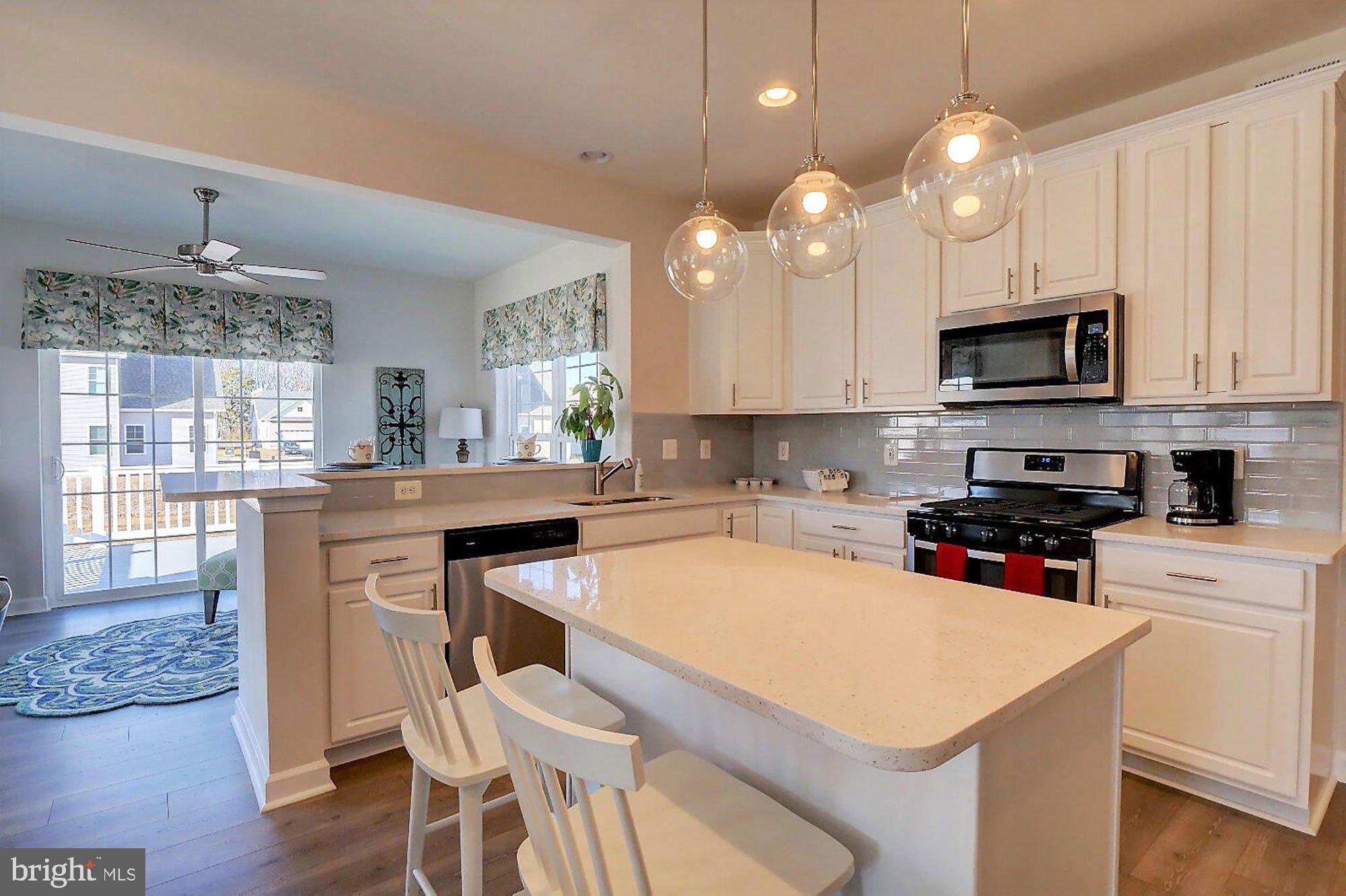 1546 Shipsview Road Annapolis, MD 21409 - Photo 9 of 13 a kitchen with a dining table chairs and white cabinets