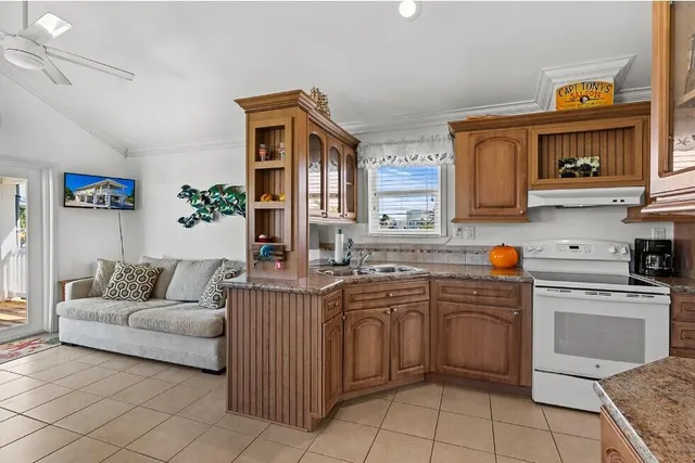 a dining hall with stainless steel appliances granite countertop a dining table and chairs with wooden floor