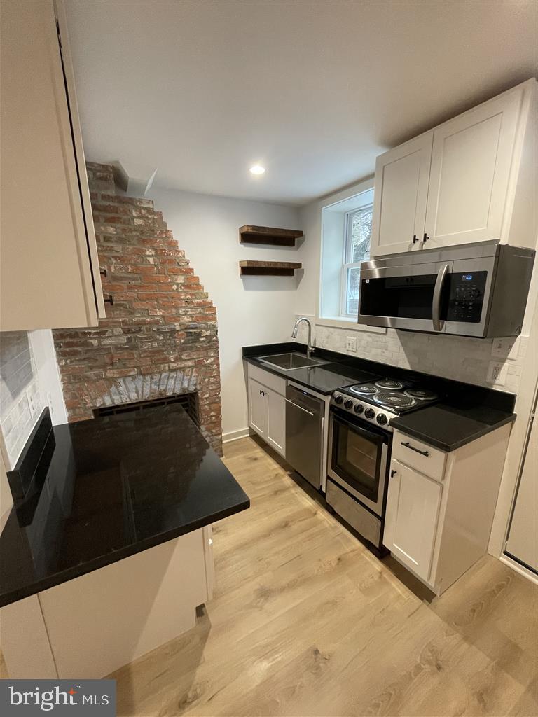 1509 Lemmon Street Baltimore, MD 21223 - Photo 3 of 14 a kitchen with granite countertop a stove and a sink