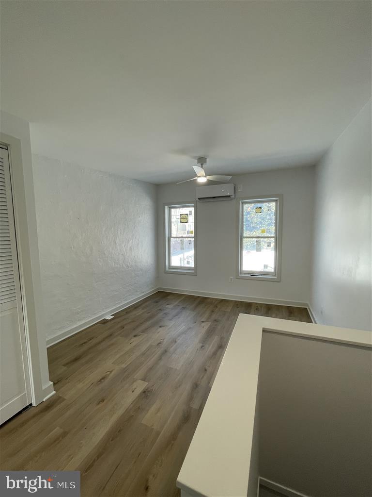 1509 Lemmon Street Baltimore, MD 21223 - Photo 6 of 14 an empty room with wooden floor and windows