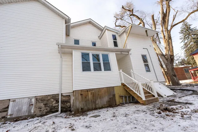 a view of an empty room with wooden floor and fence