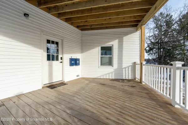 wooden floor in living room with a large window