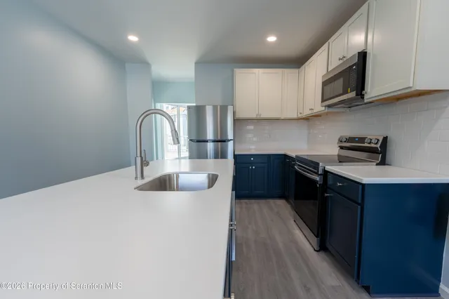 a kitchen with stainless steel appliances granite countertop a stove a sink dishwasher and a refrigerator