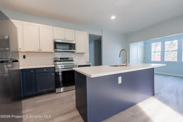 a kitchen with stainless steel appliances a sink stove and cabinets