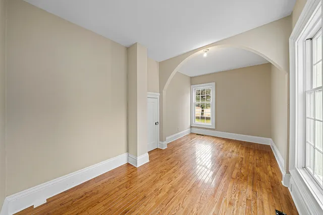 a view of a hallway with wooden floor and entryway