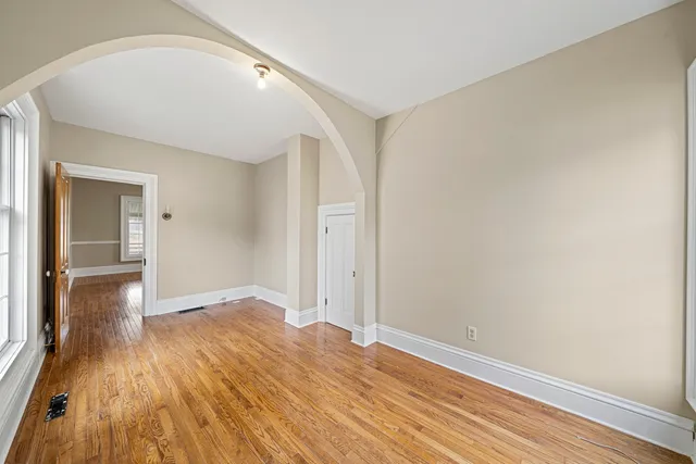 a view of a big room with windows and chandelier fan