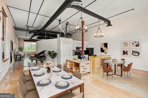 a view of a dining room with furniture a chandelier and wooden floor