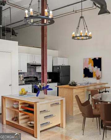 a kitchen with stainless steel appliances a stove a refrigerator and a dining table