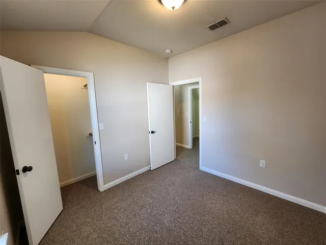 an empty room with closet and mirror