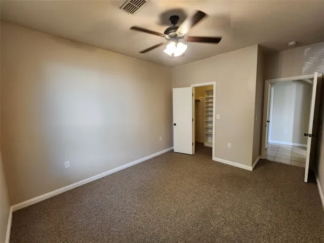 an empty room with a ceiling fan and a window
