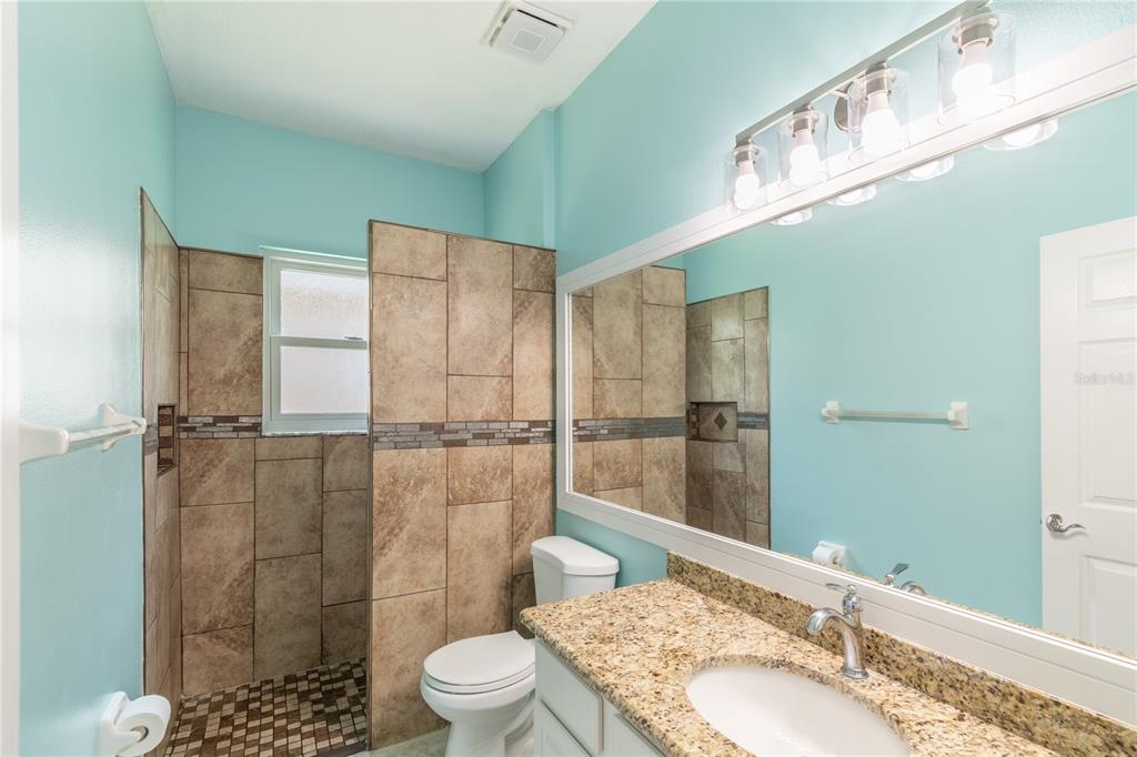 3862 Beacon Ridge Way Clermont, FL 34711 - Photo 41 of 56 a bathroom with a granite countertop sink a toilet and shower