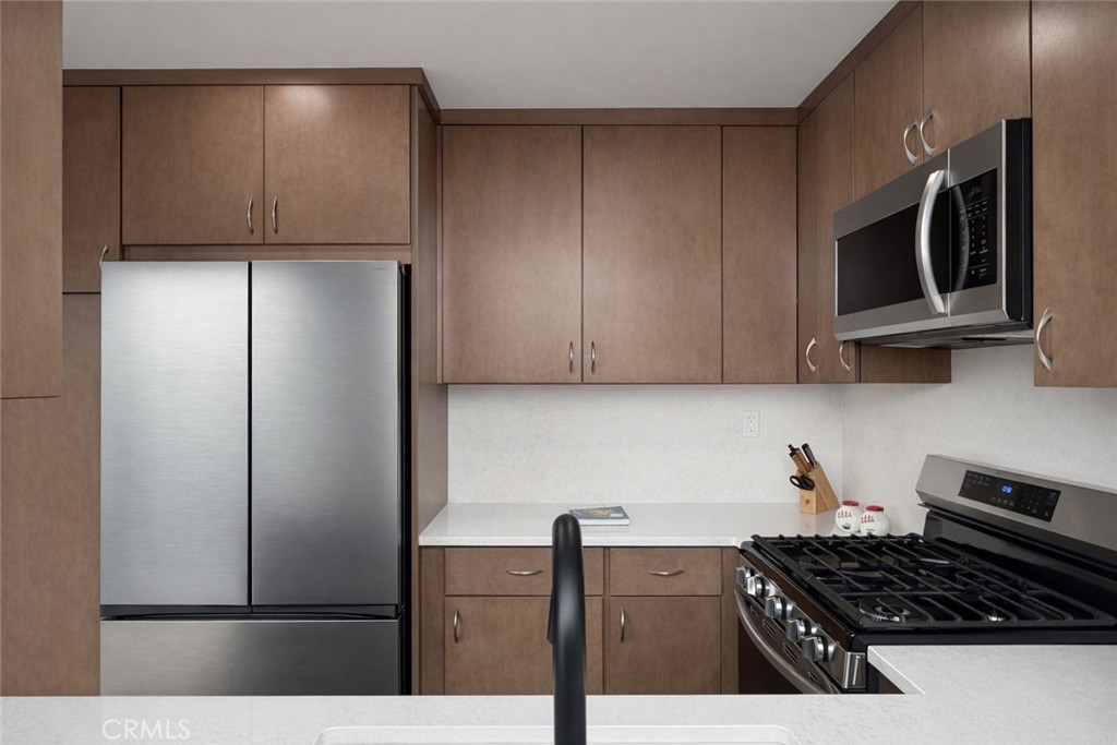 1108 18th Street, Unit 7 Santa Monica, CA 90403 - Photo 11 of 26 a kitchen with stainless steel appliances granite countertop a refrigerator and a stove top oven