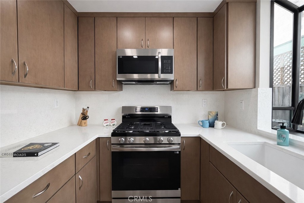 1108 18th Street, Unit 7 Santa Monica, CA 90403 - Photo 12 of 26 a kitchen with stainless steel appliances granite countertop a sink stove and microwave