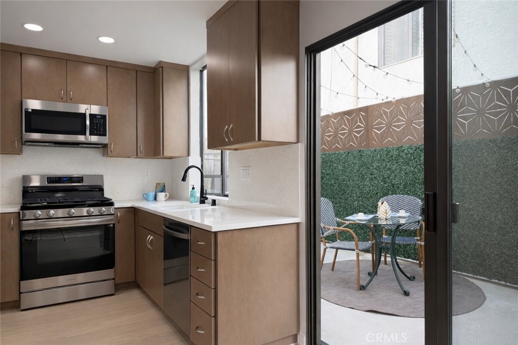 1108 18th Street, Unit 7 Santa Monica, CA 90403 - Photo 9 of 26 a kitchen with a stove a sink and a microwave
