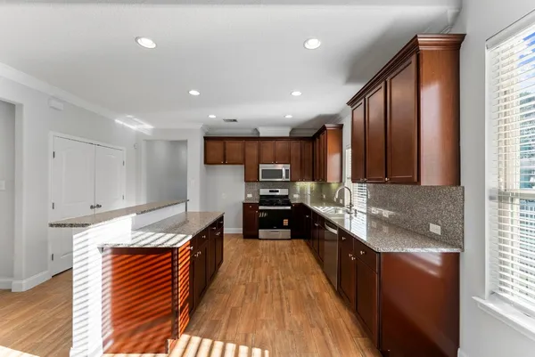 a kitchen with granite countertop stainless steel appliances and wooden cabinets