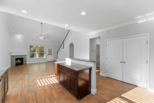 a living room with stainless steel appliances granite countertop furniture wooden floor and a fireplace