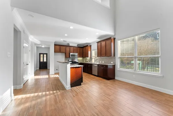 a large kitchen with stainless steel appliances granite countertop a large counter top and a wooden floors