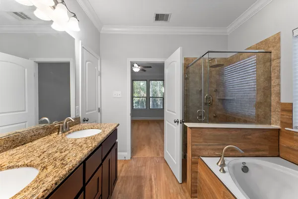 a bathroom with a granite countertop tub sink and mirror